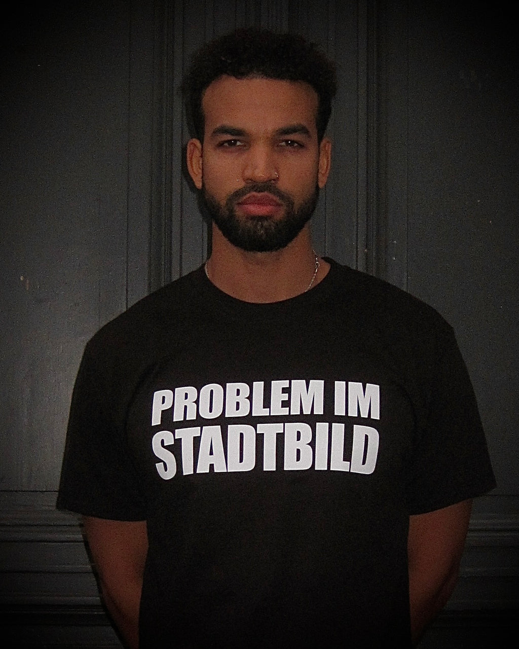 Junge Person mit ernstem Blick trägt das BBU LAB – PROBLEM IM STADTBILD T-Shirt, frontal fotografiert.
