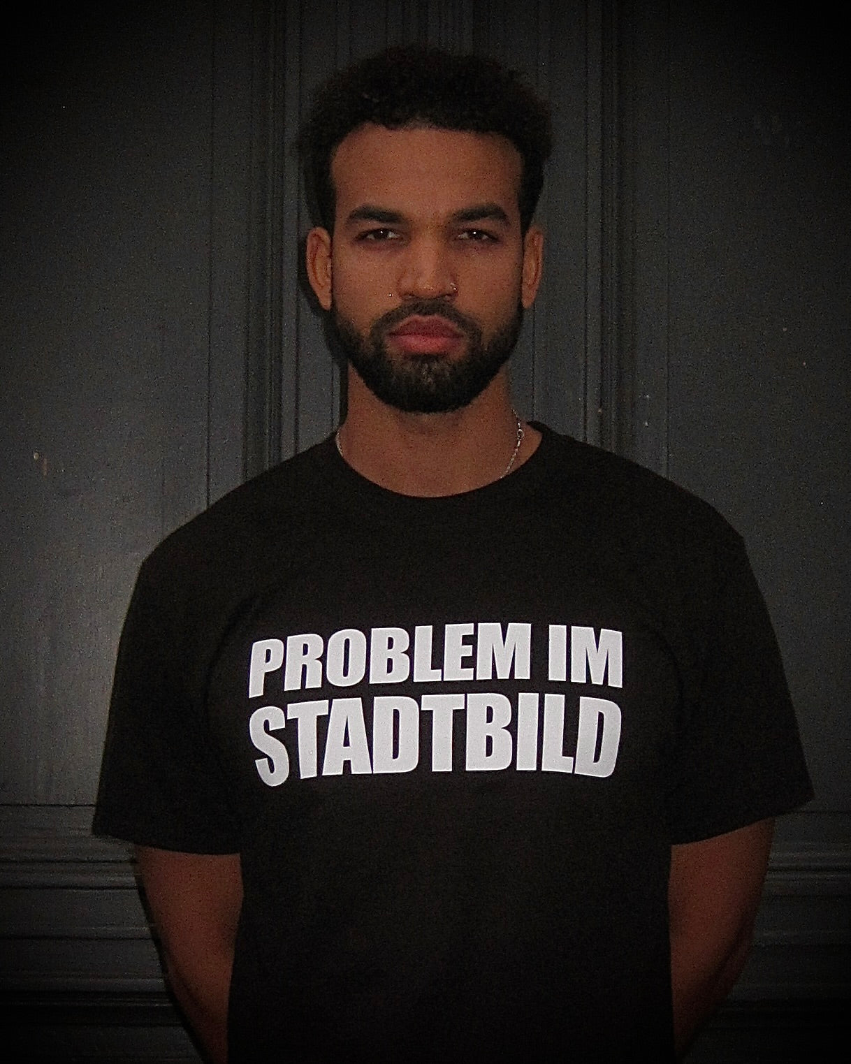 Junge Person mit ernstem Blick trägt das BBU LAB – PROBLEM IM STADTBILD T-Shirt, frontal fotografiert.