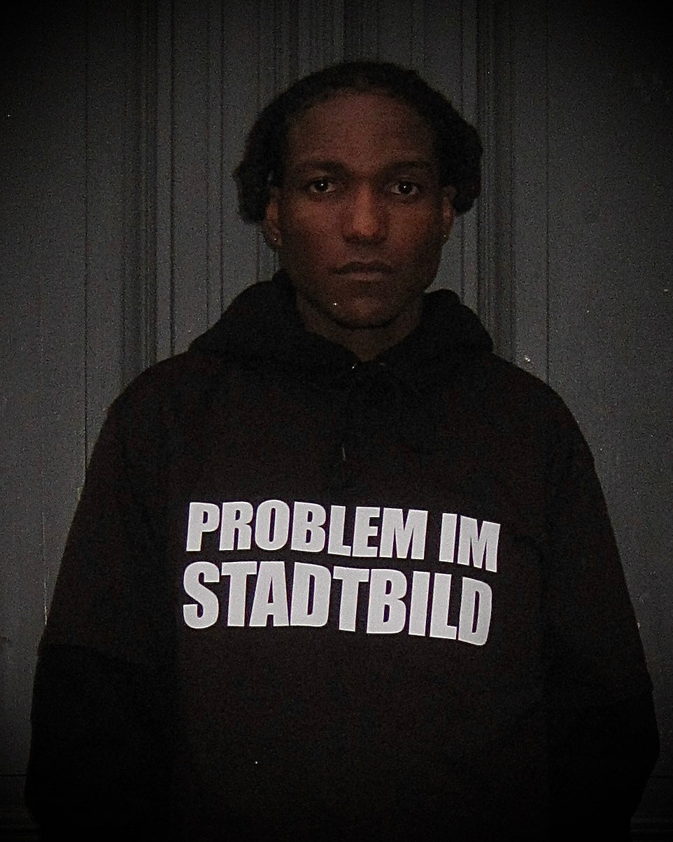 BBU LAB – schwarzes T-Shirt mit Schriftzug „Problem im Stadtbild“, Statement gegen rassistische Polizeigewalt - über Hoodie getragen